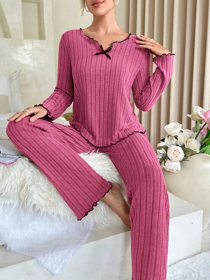 Pyjama rose femme doux et ample pour confort optimal, col en V avec noeud papillon, manches longues et pantalon long, liberté de mouvement et contours lissés, parfait pour soirées cocooning et hiver.