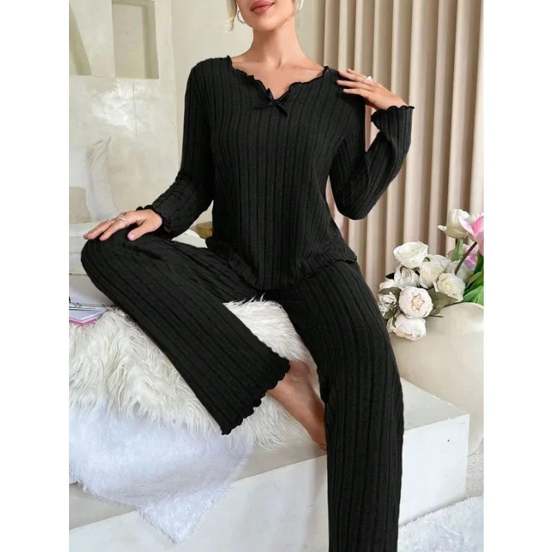 Pyjama femme noir doux et ample pour confort optimal, col en V avec noeud papillon, manches longues et pantalon long, liberté de mouvement et contours lissés, parfait pour soirées cocooning et hiver.
