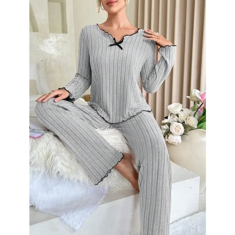 Pyjama femme gris doux et ample pour confort optimal, col en V avec noeud papillon, manches longues et pantalon long, liberté de mouvement et contours lissés, parfait pour soirées cocooning et hiver. 